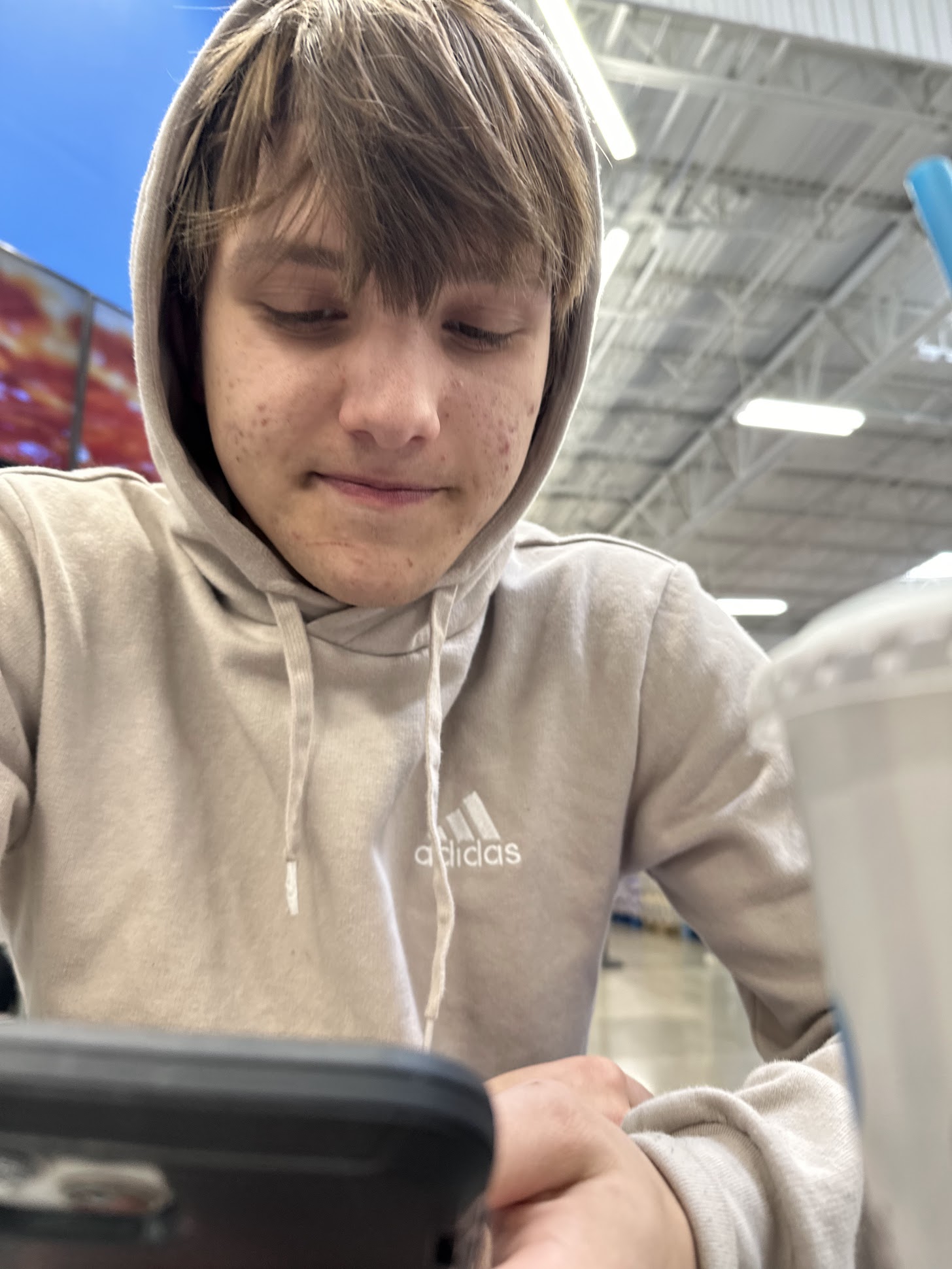 Zach in a warehouse store looking at phone
